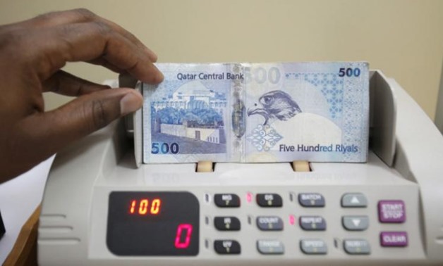 FILE PHOTO - A cashier counts Qatari riyal notes at a money changer in Doha May 28, 2013. REUTERS/Fadi Al-Assaad
