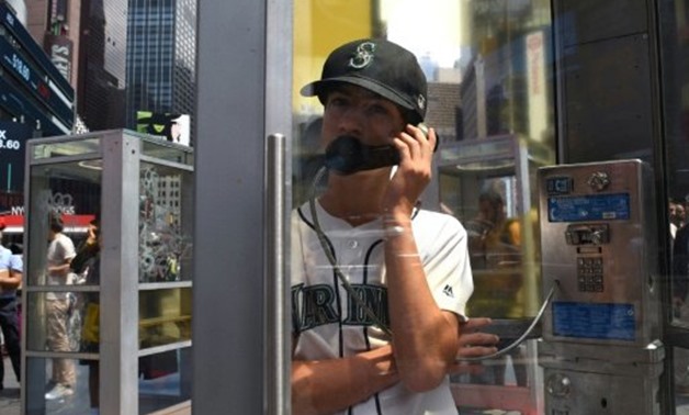 © AFP/File | Afghan-American artist Aman Mojadidi has set up phone booths in Times Square for people to listen to immigrants' stories