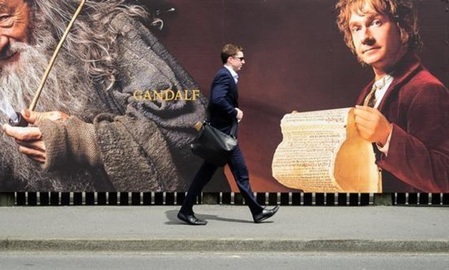 FILE PHOTO - A man walks along a fence hung with large format hoardings of J. R. R. Tolkien characters from The Hobbit movie in Wellington November 27, 2012. REUTERS/Mark Coote