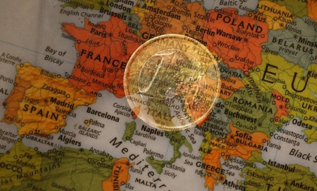 A picture illustration taken with the multiple exposure function of the camera shows a one Euro coin and a map of Europe, January 9, 2013. REUTERS/Kai Pfaffenbach