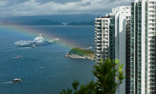 Liaoning, , arrived in Hong Kong early Friday, as a rainbow appeared overhead. (AFP Photo/RICHARD A. BROOKS)