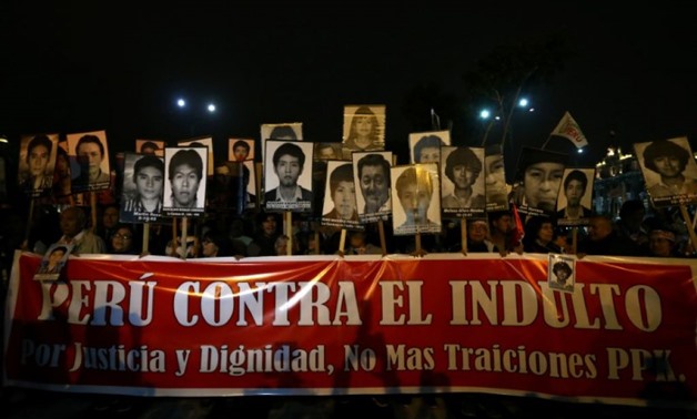 Protesters holding pictures of victims of the guerrilla conflict in the 80s and 90s march against a possible pardon for former president Alberto Fujimori in Lima. Photo: Reuters