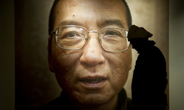 CRITICAL. A man walks in front of a poster of Chinese dissident and peace prize laureate Liu Xiaobo at an exhibition at the Nobel Peace Center in Oslo, December 9, 2010. File photo by Odd Andersen/AFP

