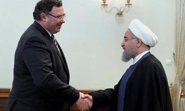 In this photo released by an official website of the office of the Iranian Presidency, President Hassan Rouhani, right, welcomes Chairman and CEO of France's Total SA Patrick Pouyanne for their meeting at his office in Tehran, Iran, Monday, July 3, 2017. 