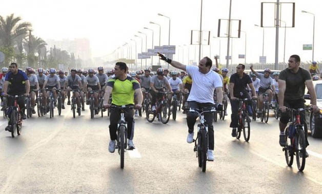 Egypt's President Abdel Fattah al-Sisi (2nd R) waves as he rides a bicycle with few hundred Egyptians outside the military college in Cairo, June 13, 2014, in this handout picture provided by the Egyptian Presidency. REUTERS