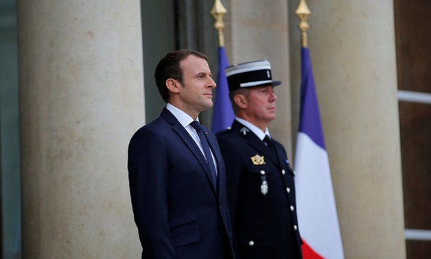 French President Emmanuel Macron stands next to Gendarmerie Commander Jean-Sylvain Gable as he waits for the arrival of German Chancellor Angela Merkel before a Franco-German joint cabinet meeting at the Elysee Palace in Paris, France, July 13, 2017. REUT