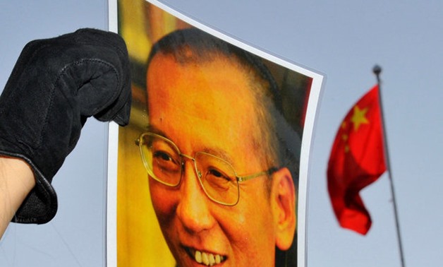FILE PHOTO: A protester holds an image of jailed dissident Liu Xiaobo outside the Chinese Embassy in Oslo, Norway December 9, 2010. REUTERS/Toby Melville/File Photo

