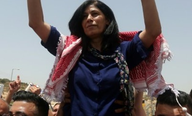 © AFP/File | (FILES) This file photo taken on June 03, 2016 shows prominent Palestinian lawmaker Khalida Jarrar flashing a victory sign as she is lifted up by supporters following her release from an Israeli jail
