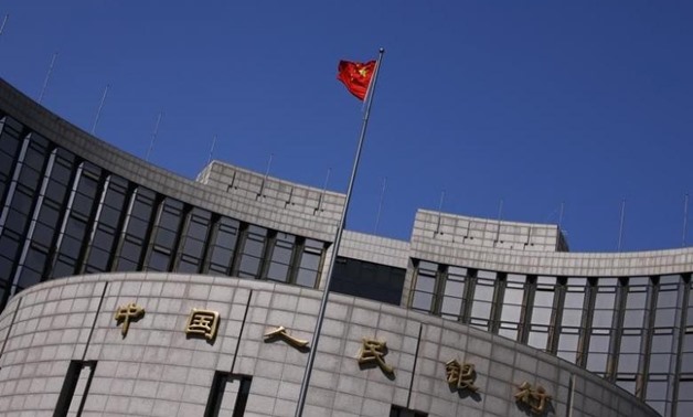A Chinese national flag flutters outside the headquarters of the People's Bank of China- Reuters
