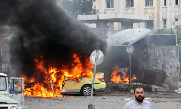 A car in flames at the scene of bombings in the Syrian city - Press photo