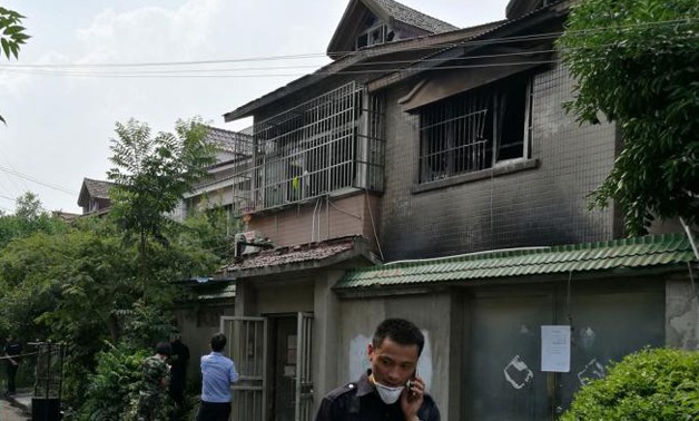 People are seen outside a residential building where a fire that broke out in the early morning killed and injured many residents - Reuters 