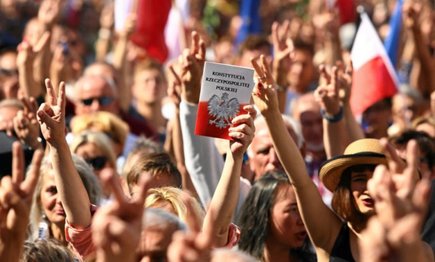 A protester holds a copy of the Polish Constitution during an opposition protest at the Market Square in Krakow - Reuters