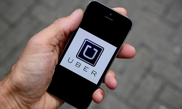 FILE PHOTO: A photo illustration shows the Uber app logo displayed on a mobile telephone, as it is held up for a posed photograph in central London, Britain October 28, 2016. REUTERS/Toby Melville