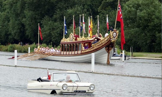 An amphibious car passes Queen Elizabeth II’s royal barge Gloriana at the Thames Traditional Boat Festival near Henley-on-Thames, Britain, July 15, 2017. Picture taken July 15, 2017- Reuters