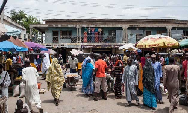This file photo taken on July 4, 2017 shows people walking among stalls at the Monday-Market, one of the biggest markets, in Maiduguri in northeastern Nigeria. Mangoes and watermelons, prayer mats and Chinese-made utensils are again filling the stalls of 