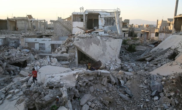 Syrian children play amidst the debris of buildings in the rebel-held town of al-Nashabiyah in the Eastern Ghouta region