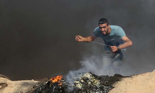 A Palestinian protester reacts during clashes with Israeli troops near the border between Israel and central Gaza Strip July 21, 2017. REUTERS/Ibraheem Abu Mustafa

