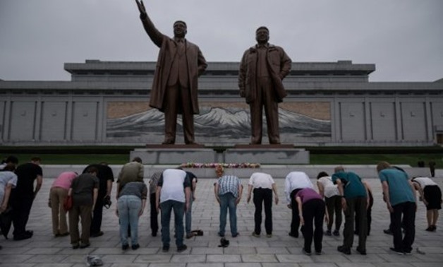 © AFP / by Sebastien BERGER | Tourists bow before statues of late North Korean leaders Kim Il-Sung (L) and Kim Jong-Il (R), on Mansu hill
