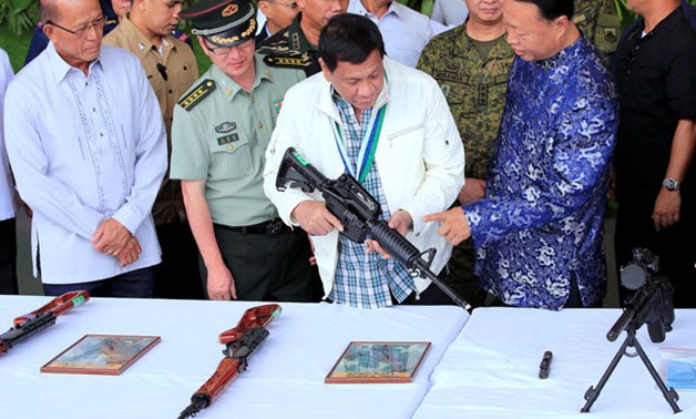 Duterte inspects automatic rifle at Clark Air Base near Angeles City - Reuters