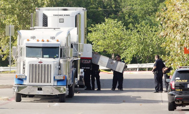 Police forensics officers work on a crime scene where eight people were found dead in San Antonio - Reuters