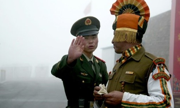 © AFP/File | A Chinese soldier, left, and his Indian counterpart are seen at the Nathu La border crossing between India and China in this 2008 file picture.
