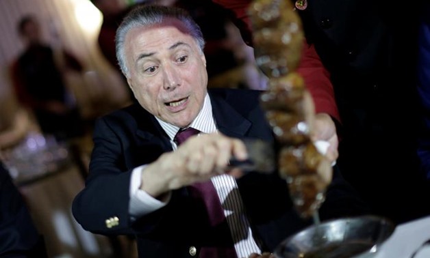 Brazil's President Michel Temer eats barbecue in a steak house after a meeting with ambassadors of meat importing countries of Brazil, in Brasilia, Brazil March 19, 2017 - Reuters