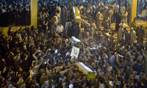 Relatives of Coptic Christians carry coffins of their relatives who were killed during a bus attack, following their funeral service, at Abu Garnous Cathedral in Minya, Egypt. Picture: AP