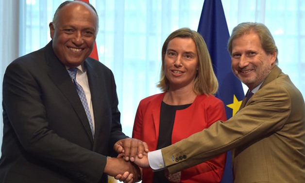 European Union foreign policy chief Federica Mogherini, European Neighborhood Policy and Enlargement Negotiations Commissioner Johannes Hahn and Egypt's Minister for Foreign Affairs Sameh Hassan Shoukry shake hands as they attend a EU-Egypt Association Co