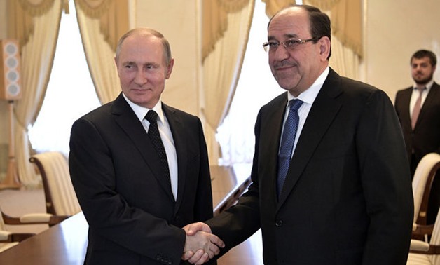 Russian President Vladimir Putin shakes hands with Iraqi Vice President Nuri al-Maliki during their meeting in St. Petersburg -REUTERS