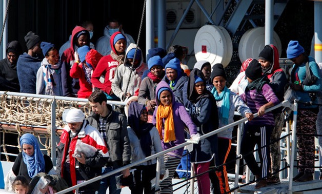 Migrants wait to disembark from German vessel FGS Rhein in the Sicilian harbour of Catania - REUTERS