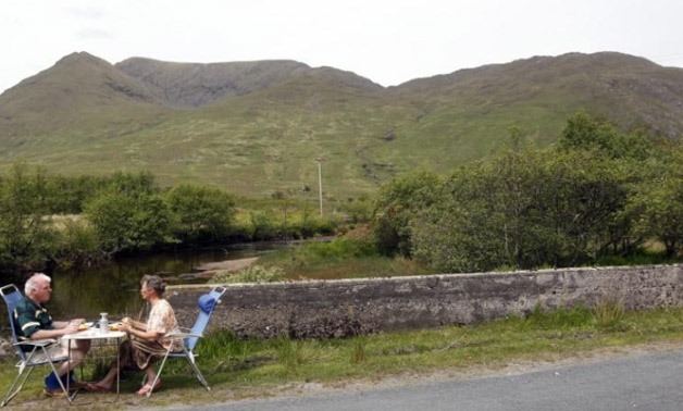 Tourists eat their lunch by the roadside in the Doo Lough Pass near the town of Wesport in County Galway on the West Coast of Ireland May - Reuters