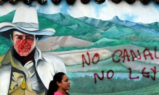 A woman is seen in front of a wall with a graffiti reading "No canal, no law" during a protest against the construction of an inter-oceanic canal in Juigalpa, Nicaragua on June 13, 2015
