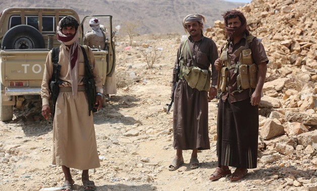 Members of the Popular Resistance militiamen backing Yemen's President Abd-Rabbu Mansour Hadi stand next to a truck as they head to the frontline of fighting against forces of Houthi rebels in Makhdara area of Marib province, Yemen