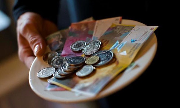 A waitress presents a plate with various Swiss Franc coins and notes in this picture illustration in a restaurant in Zurich, Switzerland, May 21, 2013.
Michael Buholzer/Illustration/File Photo