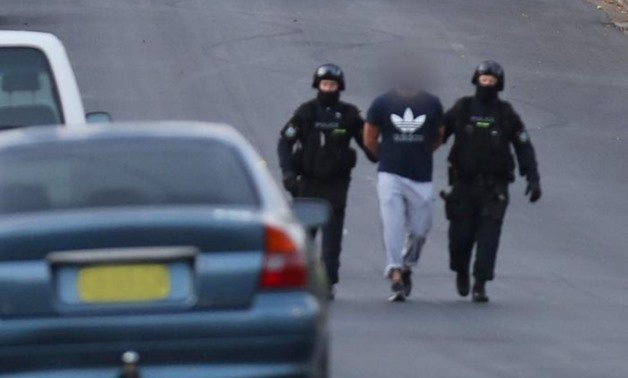 PHOTO: NSW Police lead suspects away after raids in Sydney.
