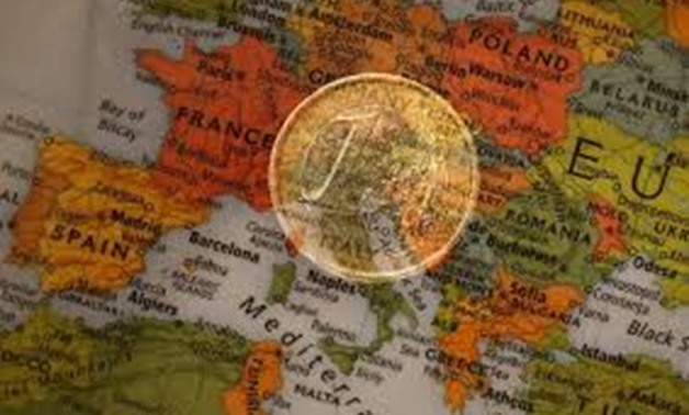 A picture illustration taken with the multiple exposure function of the camera shows a one Euro coin and a map of Europe, January 9, 2013.
