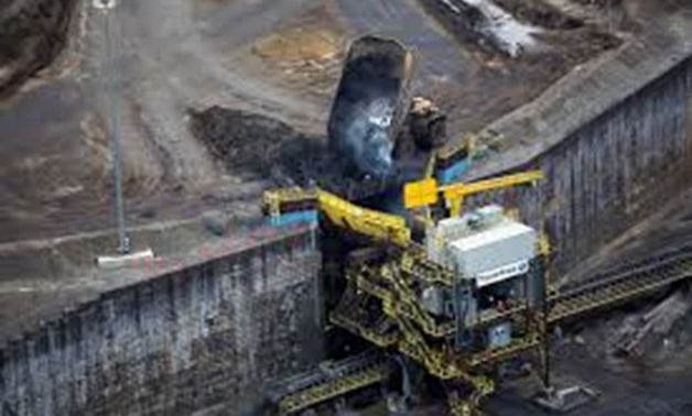 FILE PHOTO - Giant dump trucks dump raw tar sands for processing at the Suncor tar sands mining operations near Fort McMurray, Alberta, Canada on September 17, 2014.
