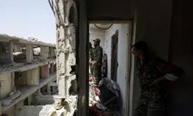 © AFP/File | Members of the US-backed Syrian Democratic Forces move through destroyed buildings in Raqa on July 28, 2017
