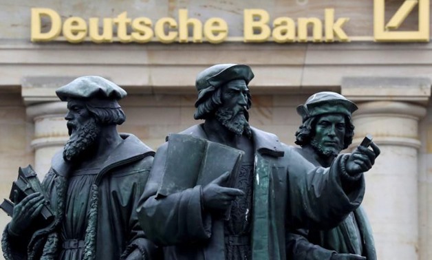 FILE PHOTO: A statue is pictured next to the logo of Germany's Deutsche Bank in Frankfurt, Germany, September 30, 2016.
Kai Pfaffenbach