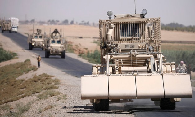 A U.S military demining vehicle leads a convoy on the main road in Raqqa - REUTERS
