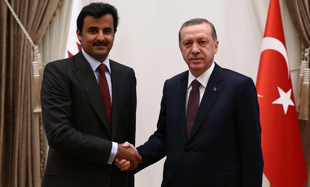 In this photo provided by the Presidential Press Service, Turkish President Recep Tayyip Erdogan, right, and Qatar's Emir Sheikh Tamim bin Hamad Al-Thani shake hands before a meeting at his new presidential palace in Ankara, Turkey, Friday, Dec. 19, 2014.