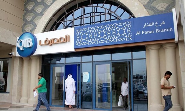 Customers leave one of the branches of Qatar Islamic Bank in Doha April