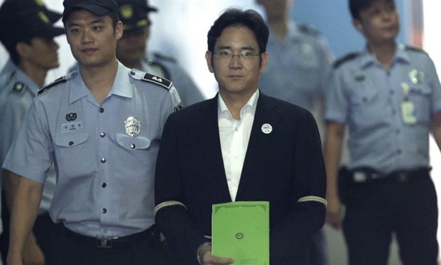 © Ahn Young-joon / AFP | Lee Jae-yong (C), vice chairman of Samsung Electronics Co., arrives for his trial at the Seoul Central District Court in Seoul on August 7, 2017.
