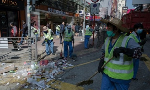 © AFP/File | Workers clear debris on a street following the Mongkok riots of February 2016
