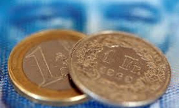 FILE PHOTO: An one euro coin and an one Swiss franc coin are seen on a one hundred Swiss franc note, in this picture illustration taken in Zurich August 8, 2011.
