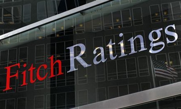 A flag is reflected on the window of the Fitch Ratings headquarters in New York in this February 6, 2013 - Reuters