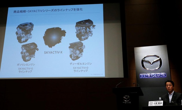 Mazda Motor President Masamichi Kogai sits next to a screen showing a slide about its new engine, to be called SKYACTIV-X, at a news conference in Tokyo, Japan August 8, 2017.
Kim Kyung-Hoon