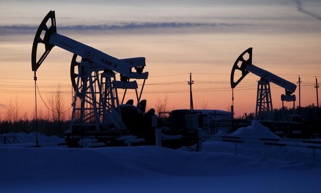 Pump jacks are seen at the Lukoil company owned Imilorskoye oil field, as the sun sets, outside the West Siberian city of Kogalym, Russia, January 25, 2016.
Sergei Karpukhin