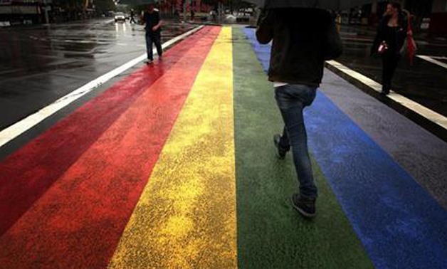 People walk across a rainbow pedestrian crossing painted on Sydney's Oxford street, the city's main gay district April 4, 2013 - Reuters