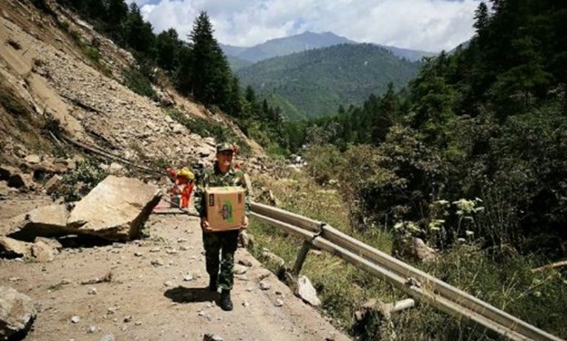 Chinese paramilitary police carry relief supplies on their way to an earthquake-struck zone in Jiuzhaigou in China's southwestern Sichuan province - AFP